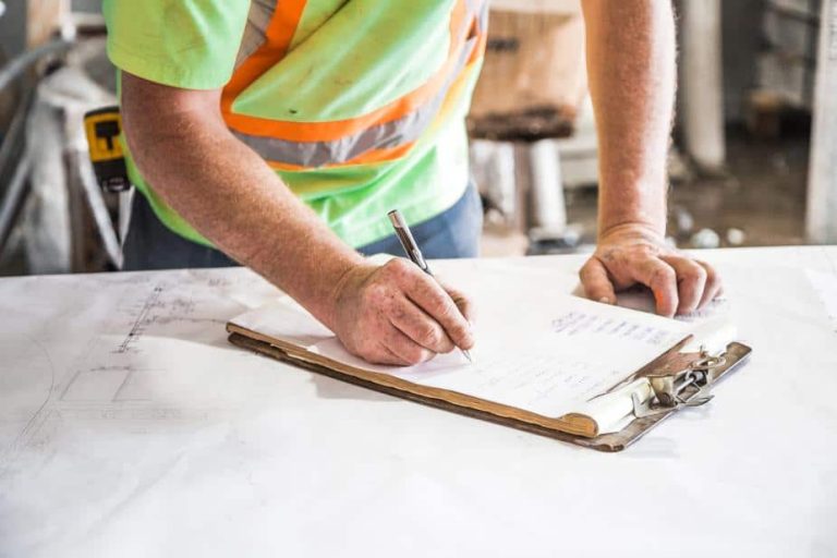 Constructeur examinant des documents d'assurance décennale