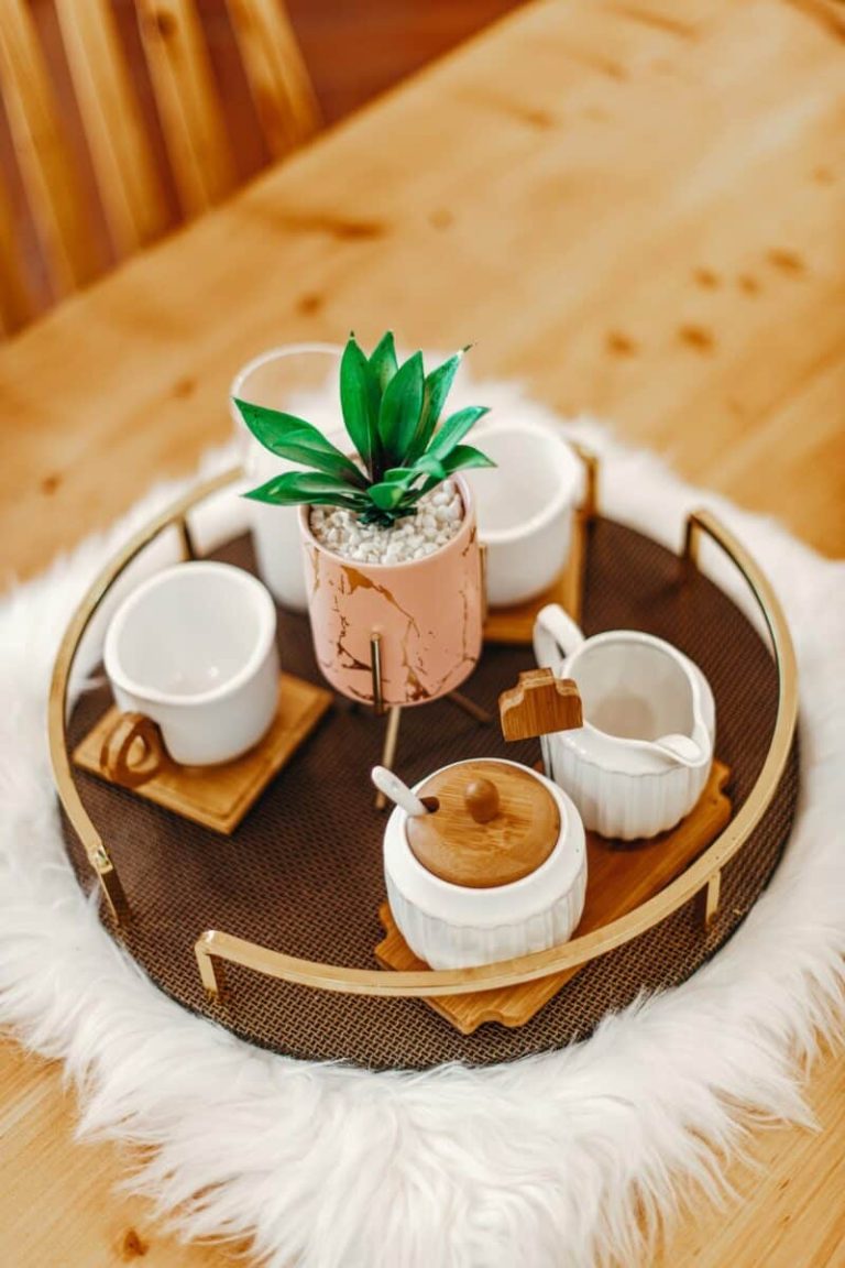 Thé blanc en tasse avec feuilles et infusions en arrière-plan
