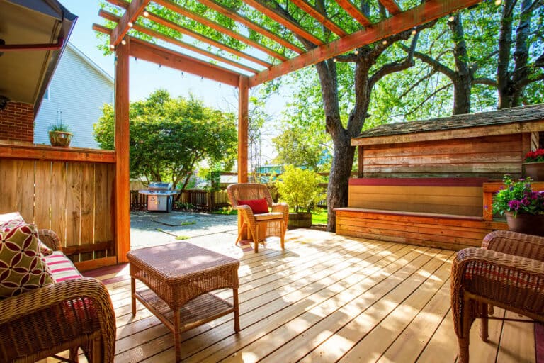 pergola en bois dans un jardin ensoleillé avec des chaises confortables