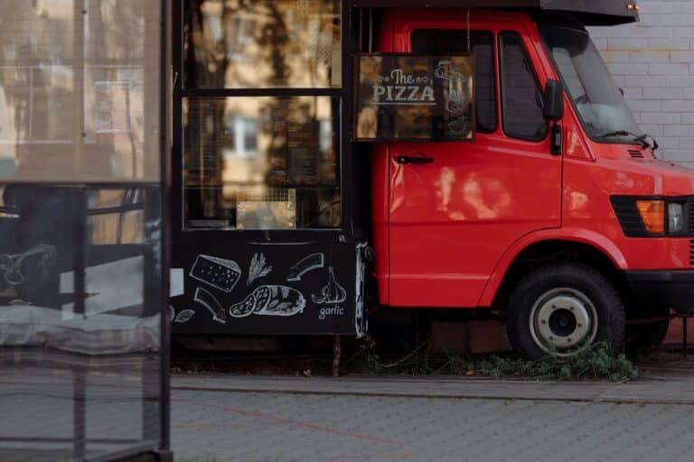 Camion pizza coloré stationné dans une rue animée avec clients heureux