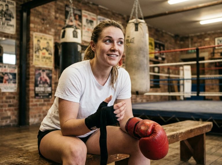 Une femme nouvellement arrivée à Paris enfile ses gants de boxe dans une salle conviviale au décor authentique