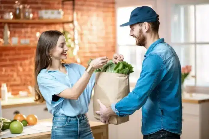 deux personnes qui tiennent un sac alimentaires de courses