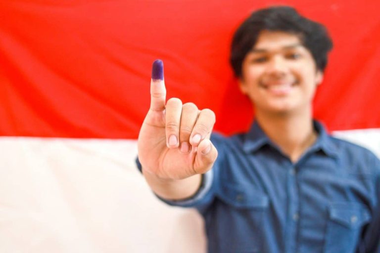 Homme montrant son doigt encre après avoir voté aux élections