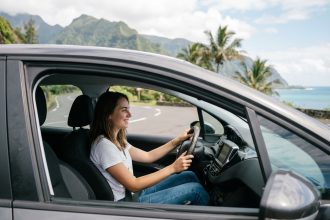 Jeune femme dans une voiture à La Réunion avec paysage volcanique