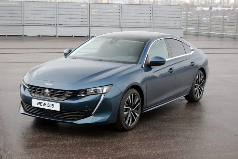 Peugeot 508 garée devant un paysage urbain moderne