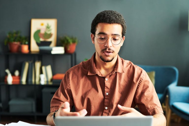 Jeune homme d'affaires discutant en ligne sur un ordinateur portable